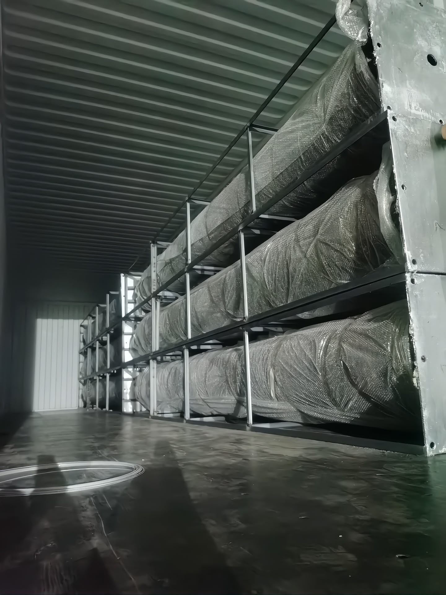 Loaded in tiers on steel racks — upright, not loose-packed