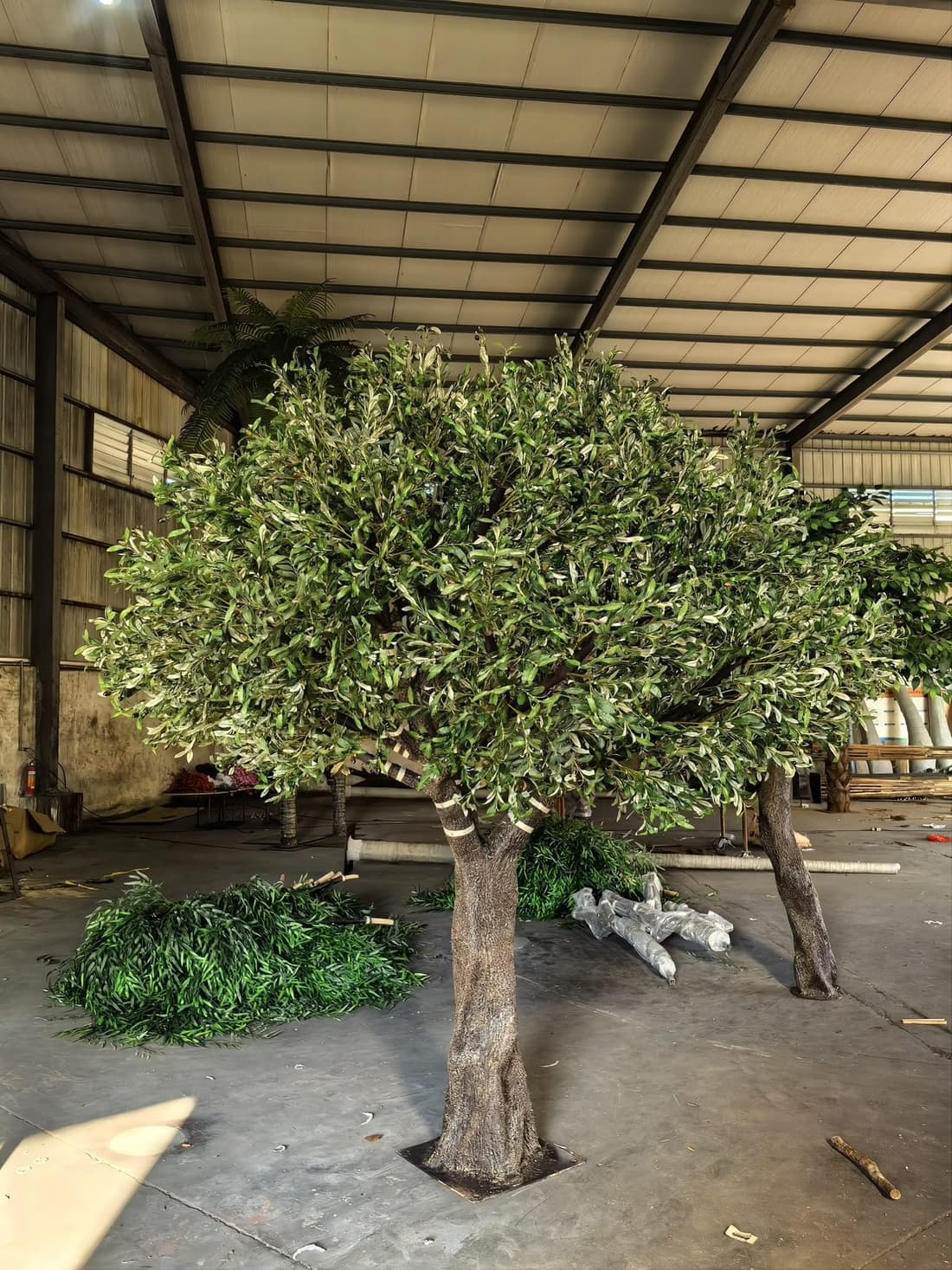 Close view of an artificial olive tree canopy with narrow two-tone leaves on fine branches