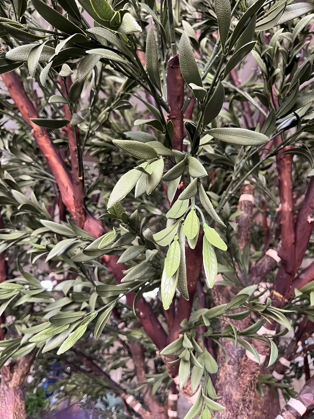 Olive foliage up close — colour-matched PE leaves with a fabric-textured reverse