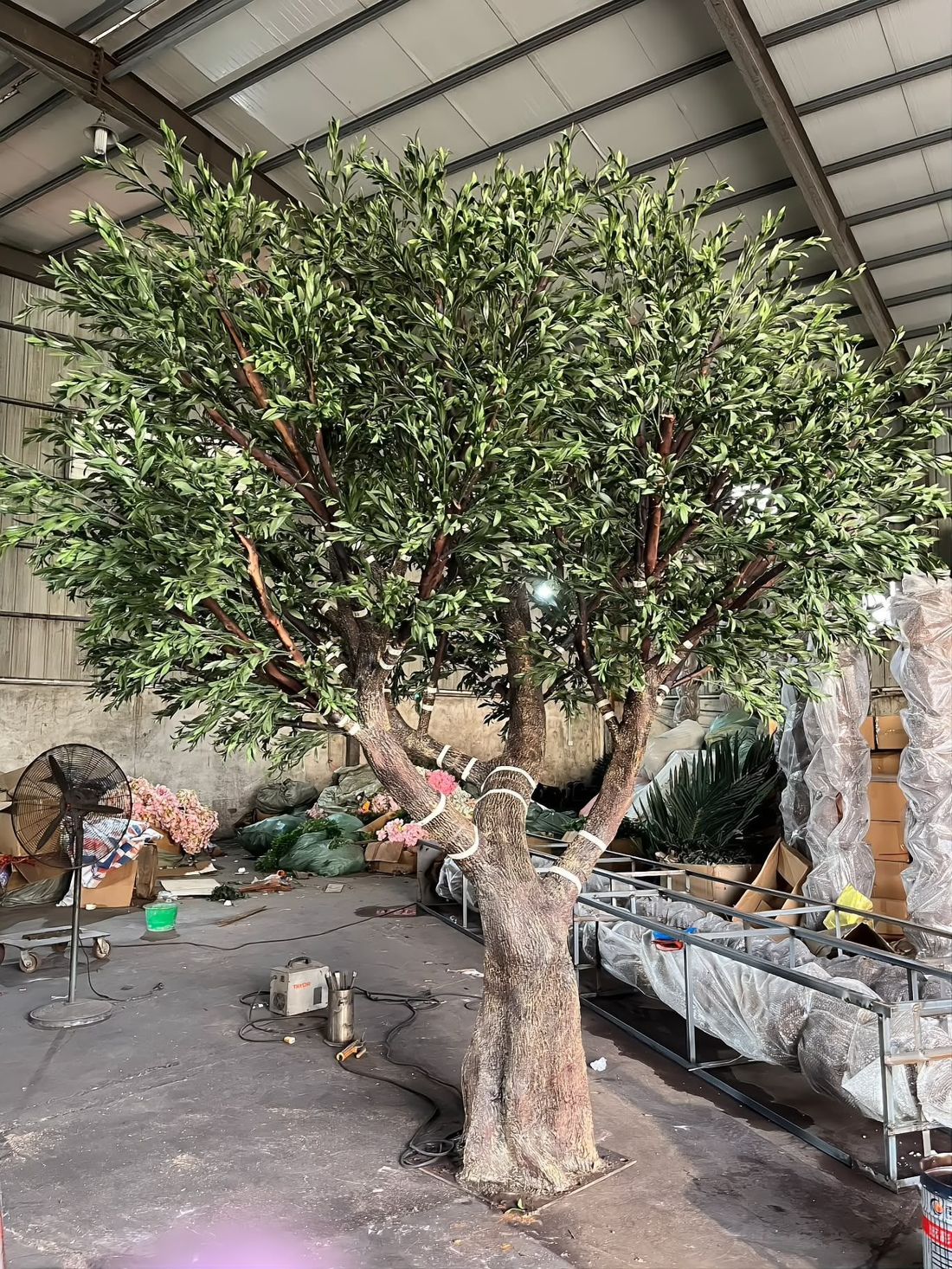 Oversized tree on the shop floor, checked against a 1.7 m reference