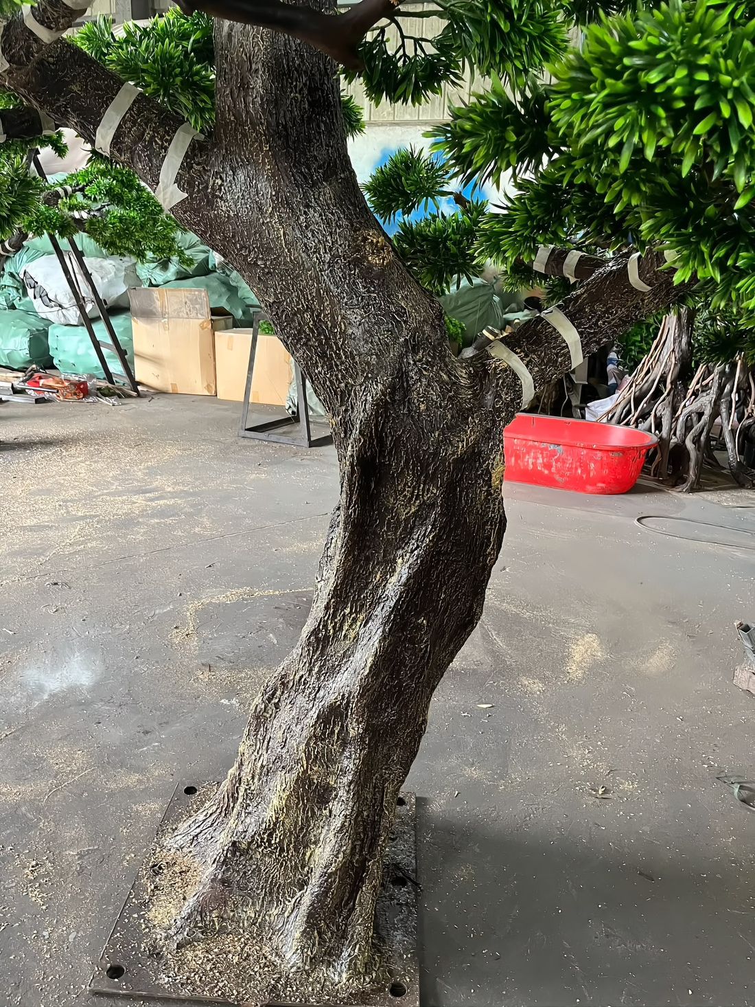 Sculpted trunk detail — the S-curve is shaped by hand, then textured and painted