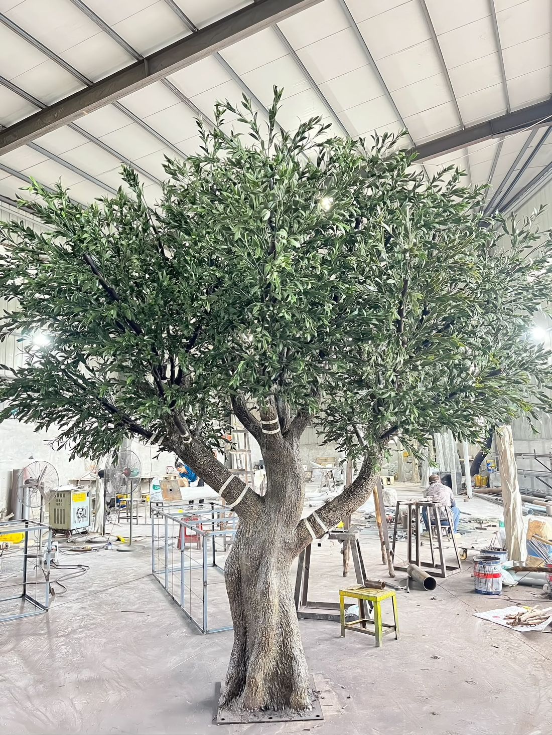 Assembly bay — canopies built onto finished trunks, one tree to a station
