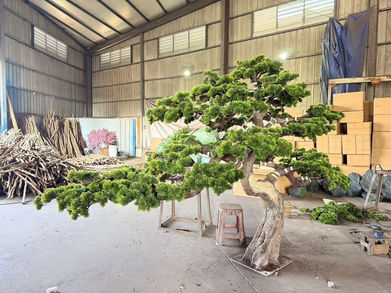 Sculpted topiary production overview in the Everflorae workshop with a form mid-build and frames staged around it
