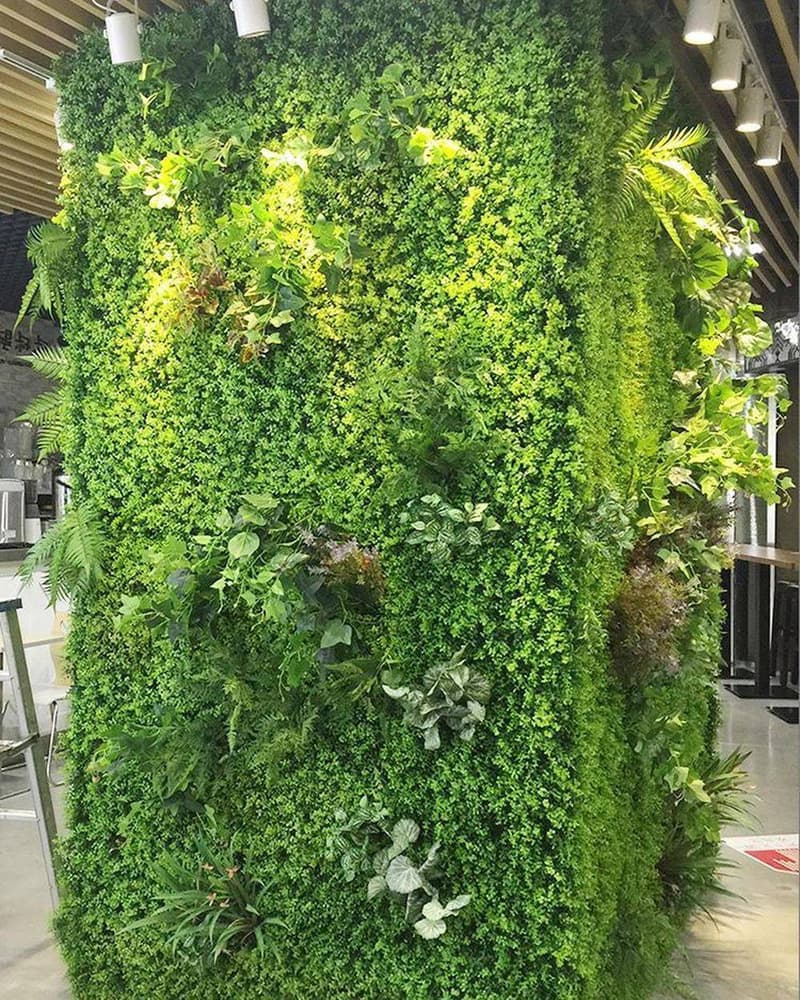 Flame-retardant artificial foliage wall installed as a column feature in a commercial interior